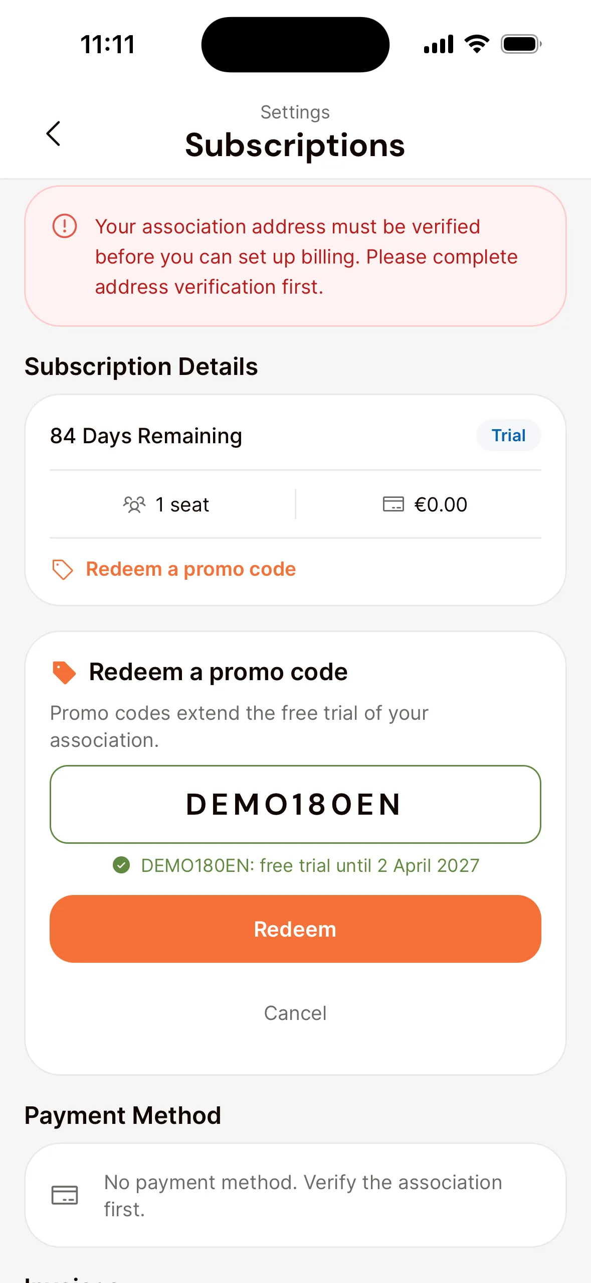 The Subscriptions screen in the app of an association that isn't verified yet, with the notice that the address must be verified first at the top and the Redeem a promo code panel: an entered code with the date the free trial would then run until, the Redeem button and Cancel.