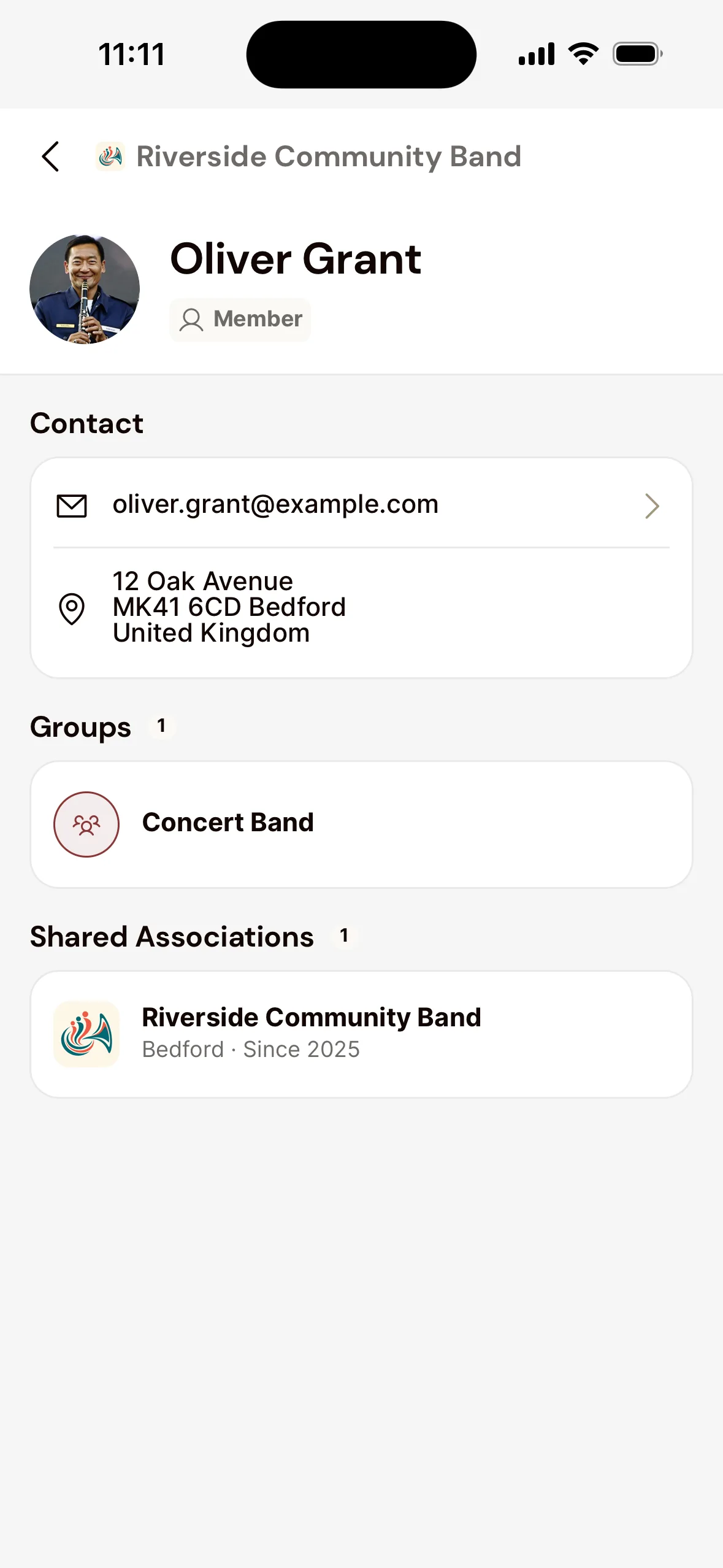 A fellow member's page in the app: name and role, under Contact the email address and address, under Groups the Concert Band and under Shared Associations the association.