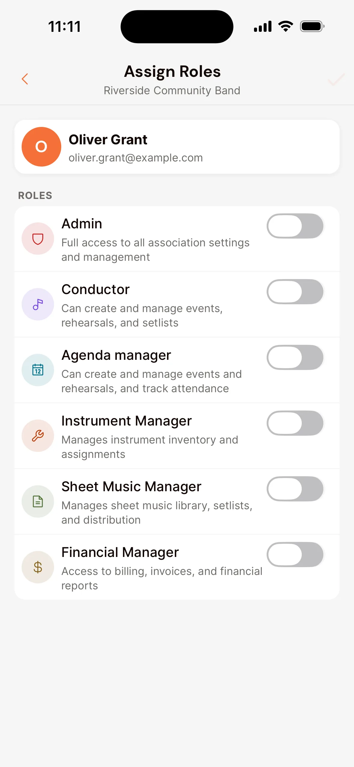 The Assign Roles screen in the app for one member: under Roles a switch per role, such as Admin, Conductor, Agenda manager, Instrument Manager, Sheet Music Manager and Financial Manager, each with an explanation.