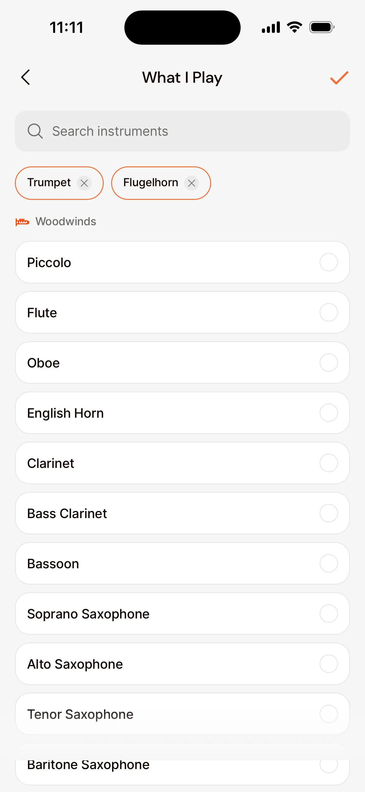 The What I Play screen in the app: the search field, the chosen instruments Trumpet and Flugelhorn, and the list of instruments by family, such as Woodwinds.