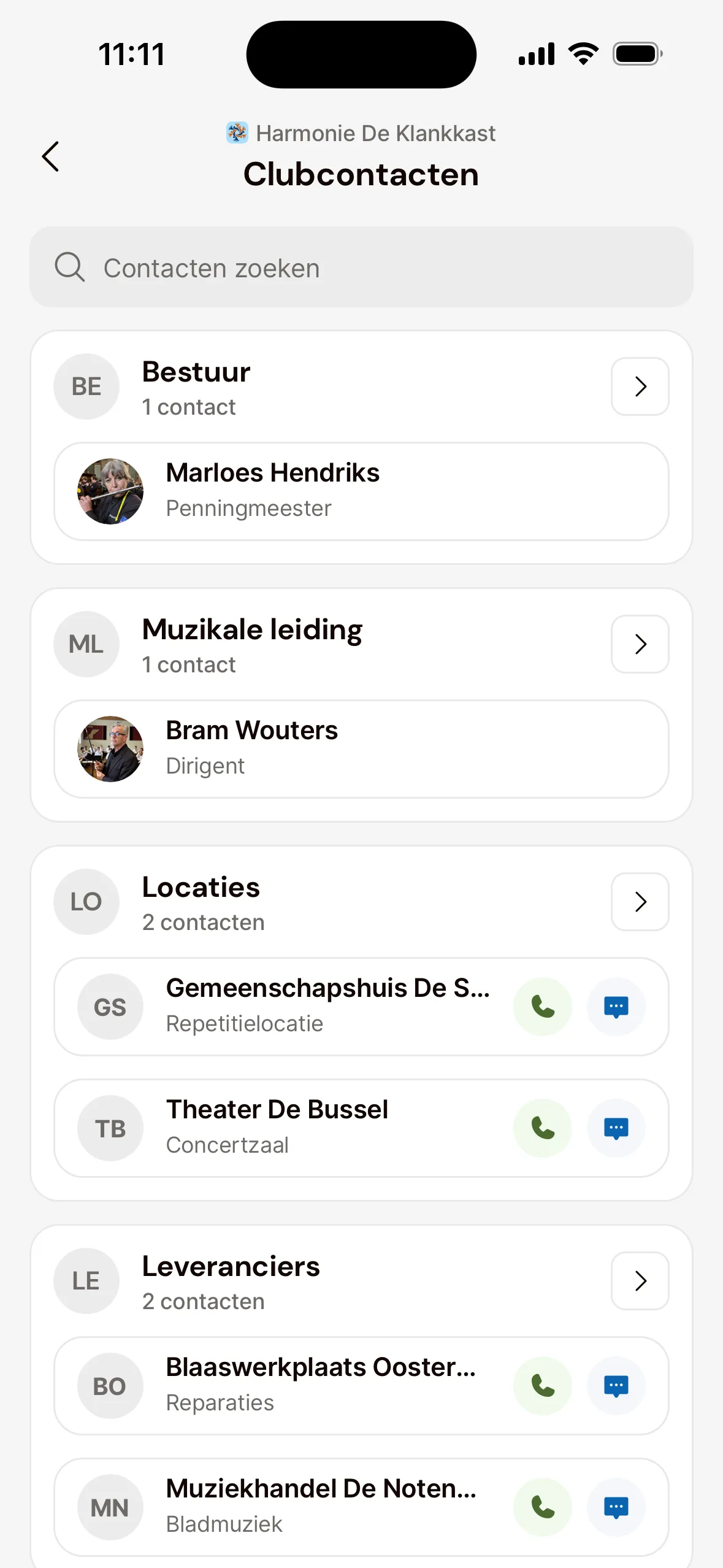 Clubcontacten in de app, per categorie, zoals Bestuur, Muzikale leiding, Locaties en Leveranciers, met bij elk contact de naam en de functie, bijvoorbeeld Penningmeester of Dirigent, en bij contacten met een telefoonnummer de knoppen om te bellen en een bericht te sturen.