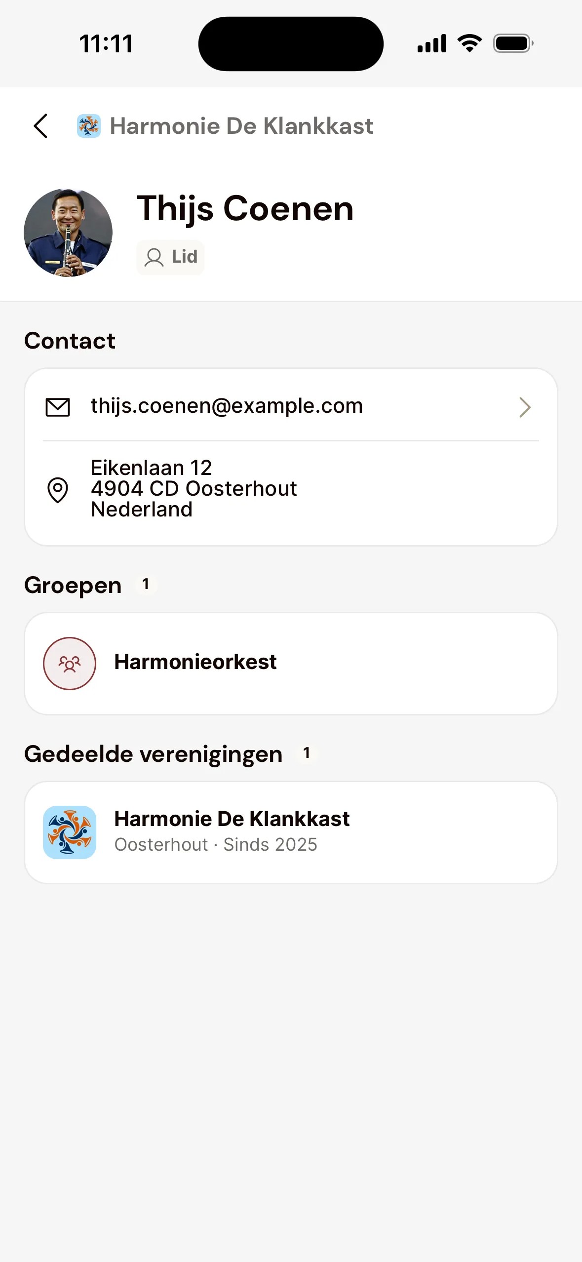 De pagina van een medelid in de app: naam en rol, onder Contact het e-mailadres en het adres, onder Groepen het Harmonieorkest en onder Gedeelde verenigingen de vereniging.