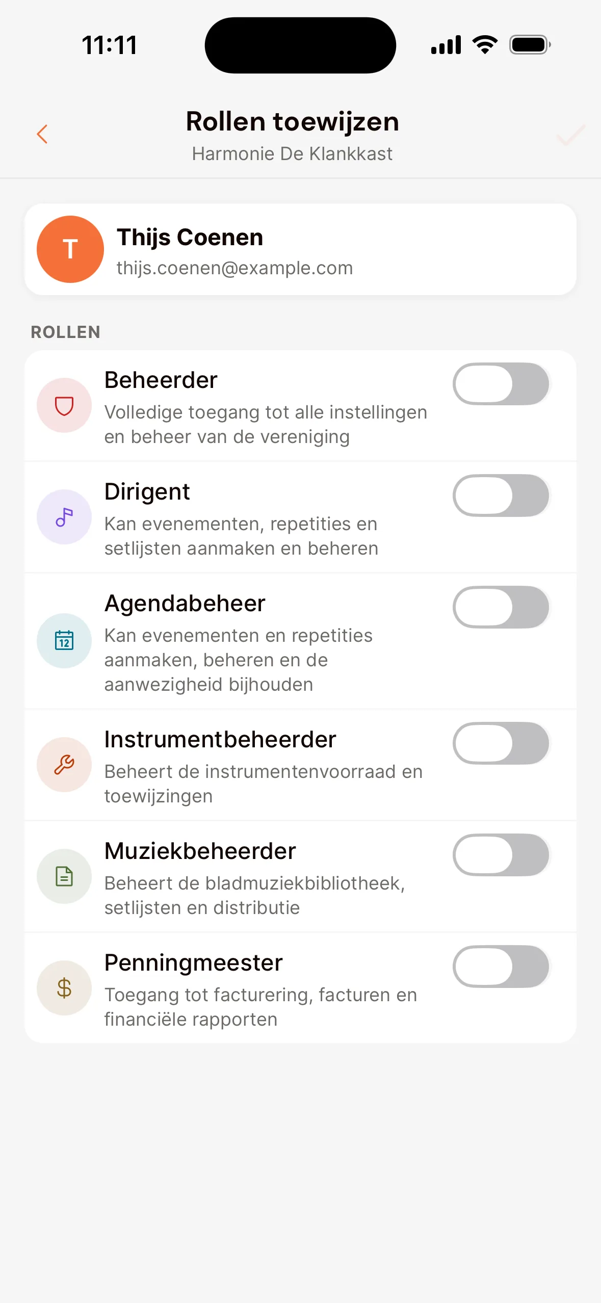 Het scherm Rollen toewijzen in de app voor één lid: onder Rollen een schakelaar per rol, zoals Beheerder, Dirigent, Agendabeheer, Instrumentbeheerder, Muziekbeheerder en Penningmeester, met uitleg bij elke rol.